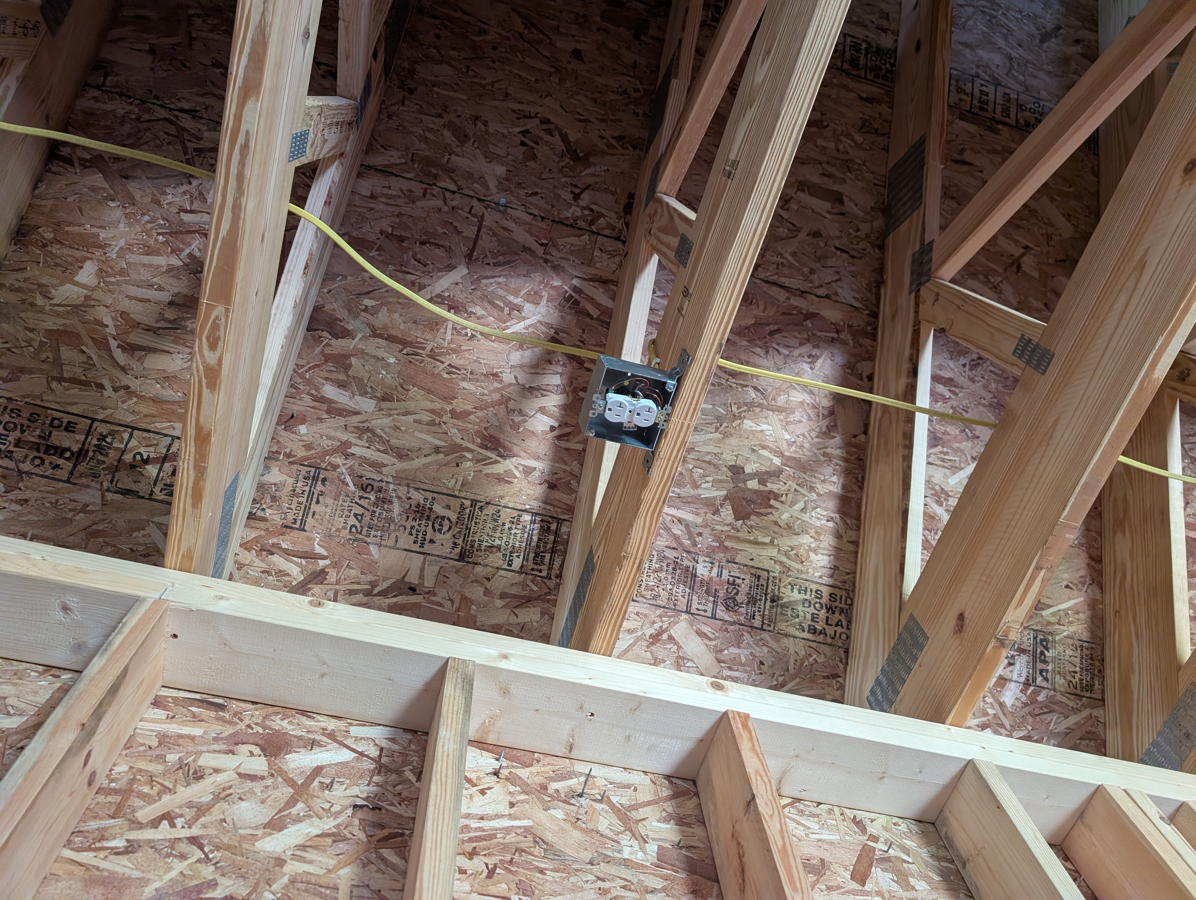 Bay 2 middle-bay 4-inch square ceiling box on an F-bracket with yellow NM-B passing through and stapled to the truss members; no mud ring yet