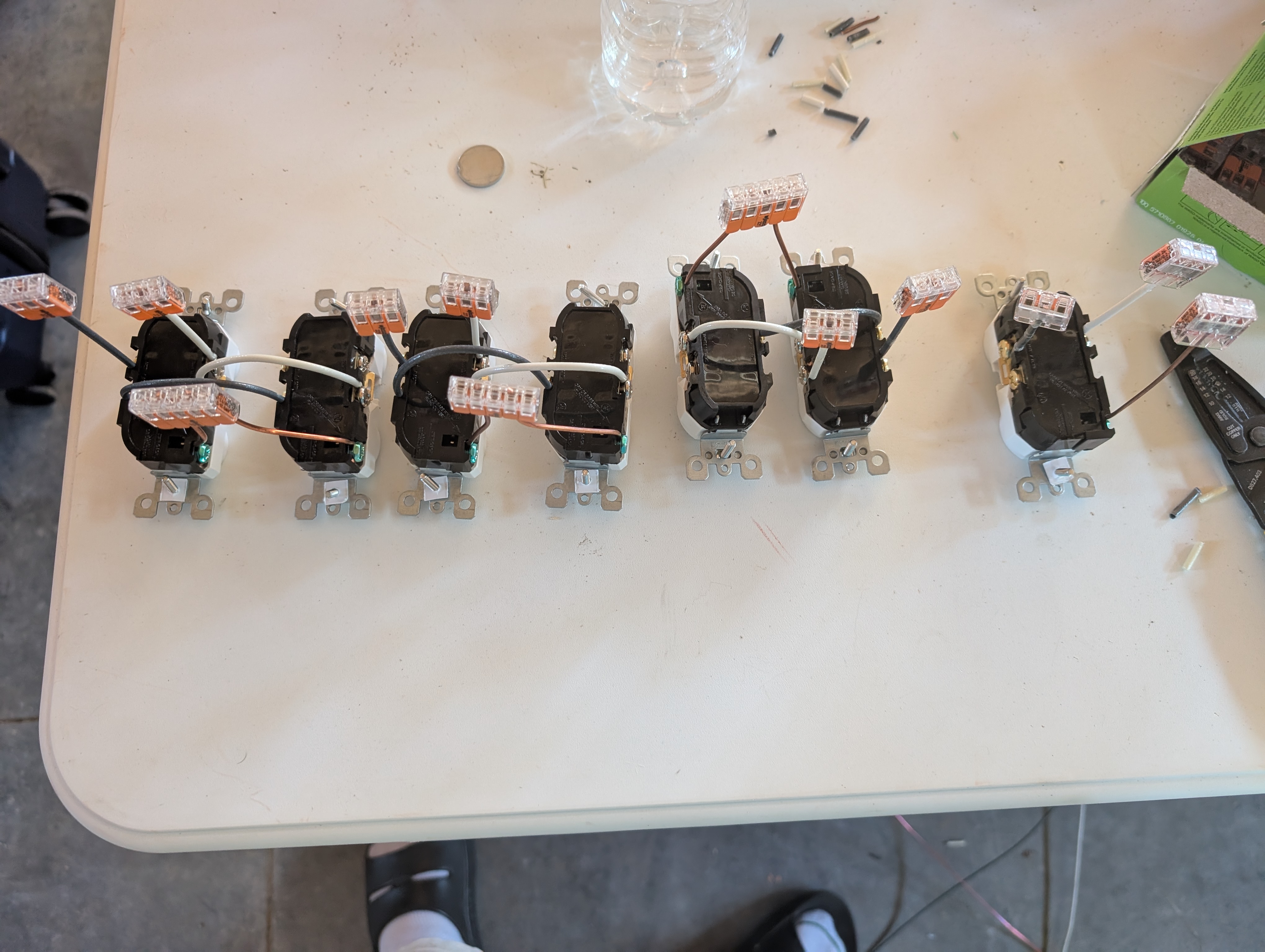 Work table with three dual-gang receptacle assemblies and one single-outlet assembly, each pre-wired with Wago 221 lever-nut pigtails for fast chaining