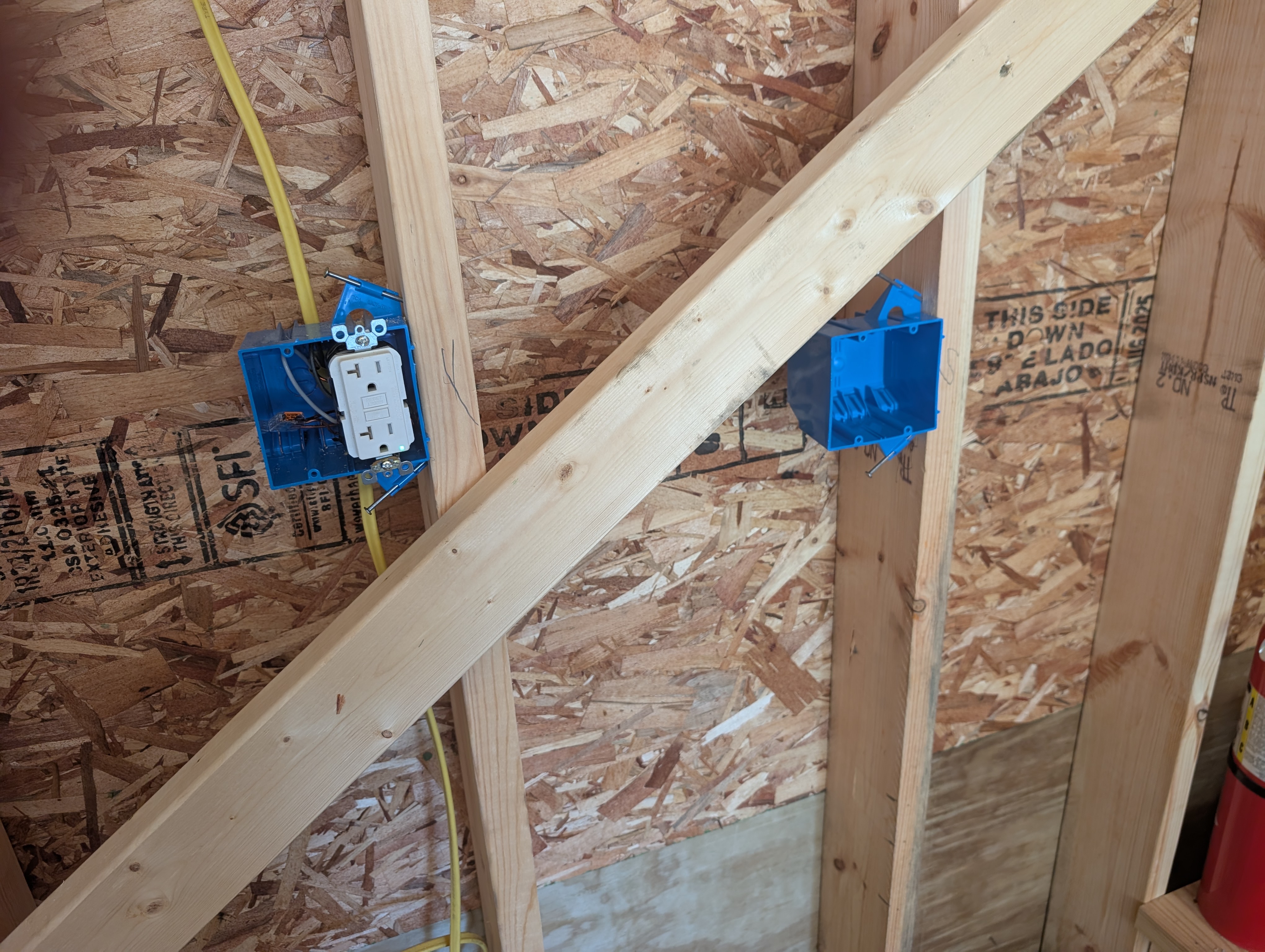 Single workbench-height duplex chained into the 16-inch row at the rolling tool-cabinet location, with a new empty 2-gang box near the stairs for the 3-way switches