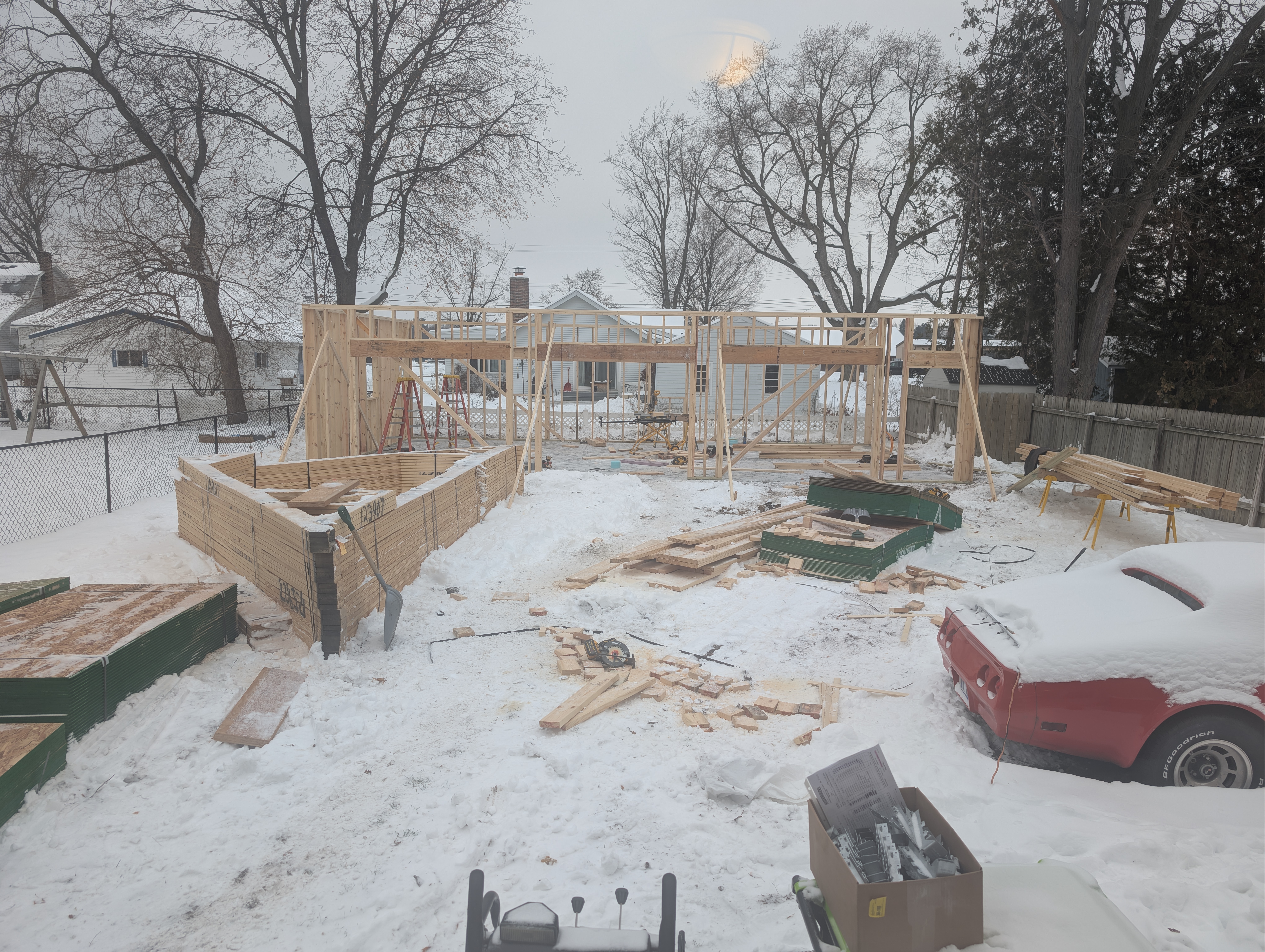 Garage framing underway with wall bracing and material staging