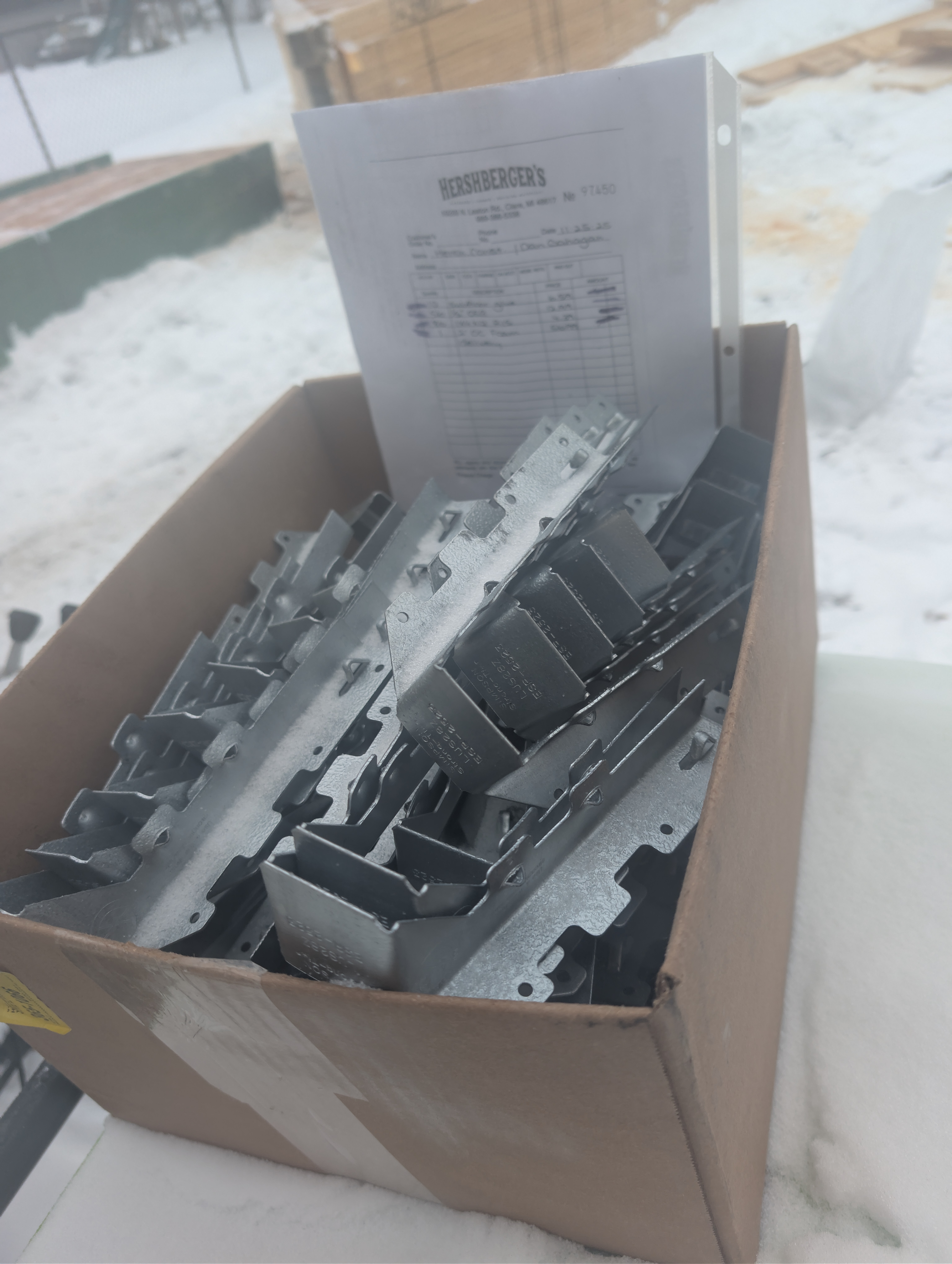 Box of Simpson Strong-Tie hangers with invoices tucked behind