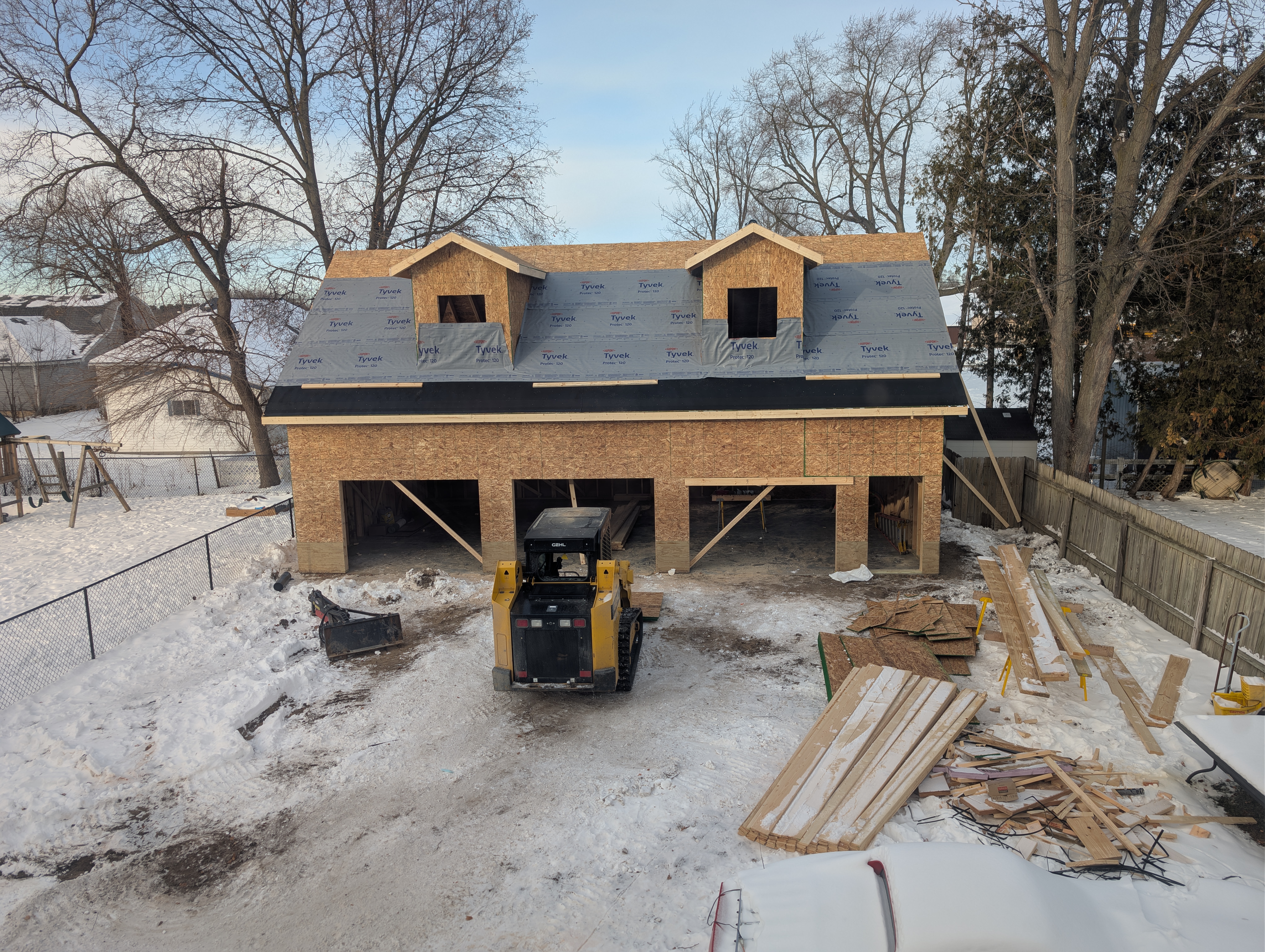 Front view showing roof underlayment and Tyvek-wrapped dormers