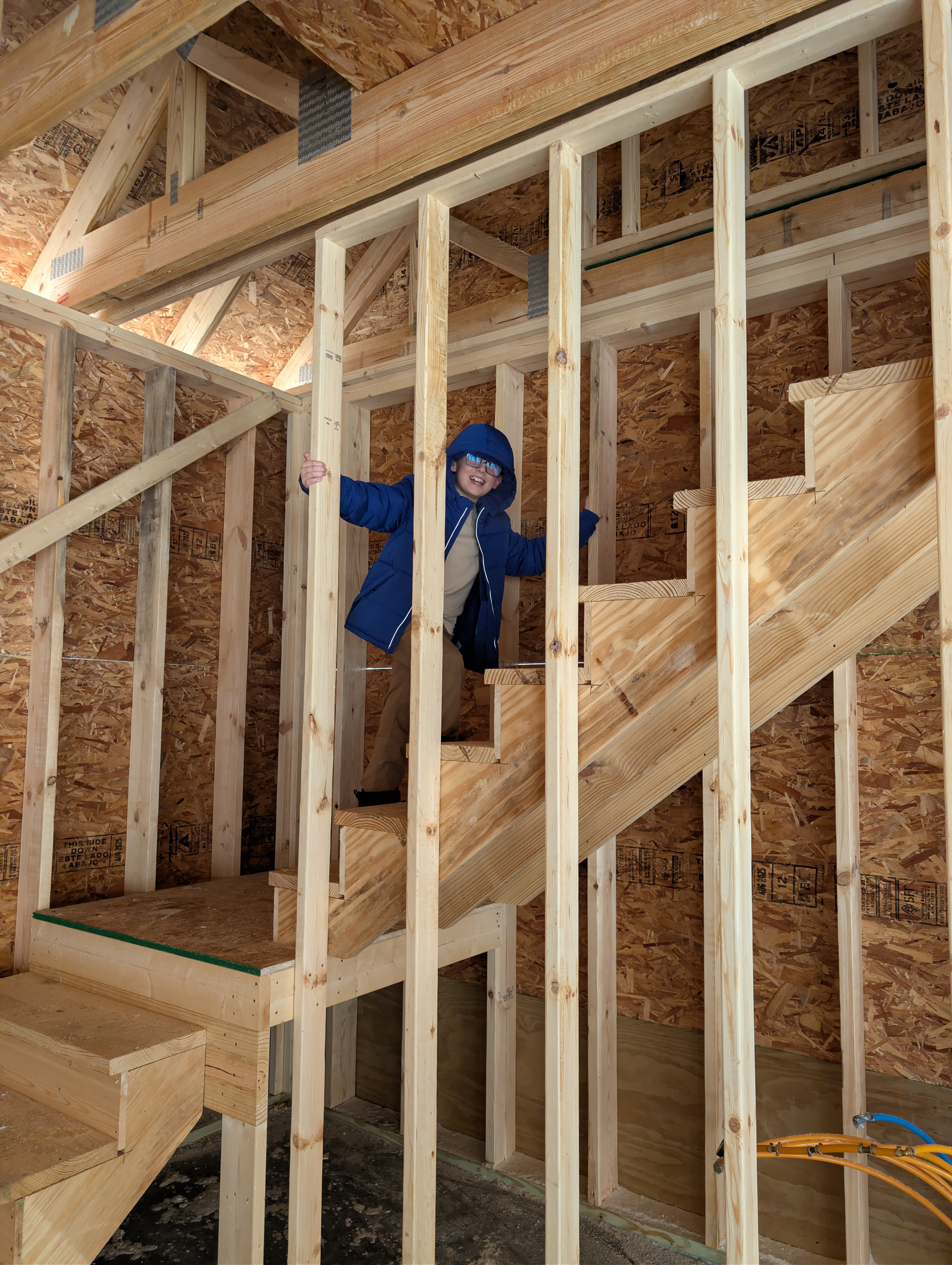 Child standing on framed stairs inside loft