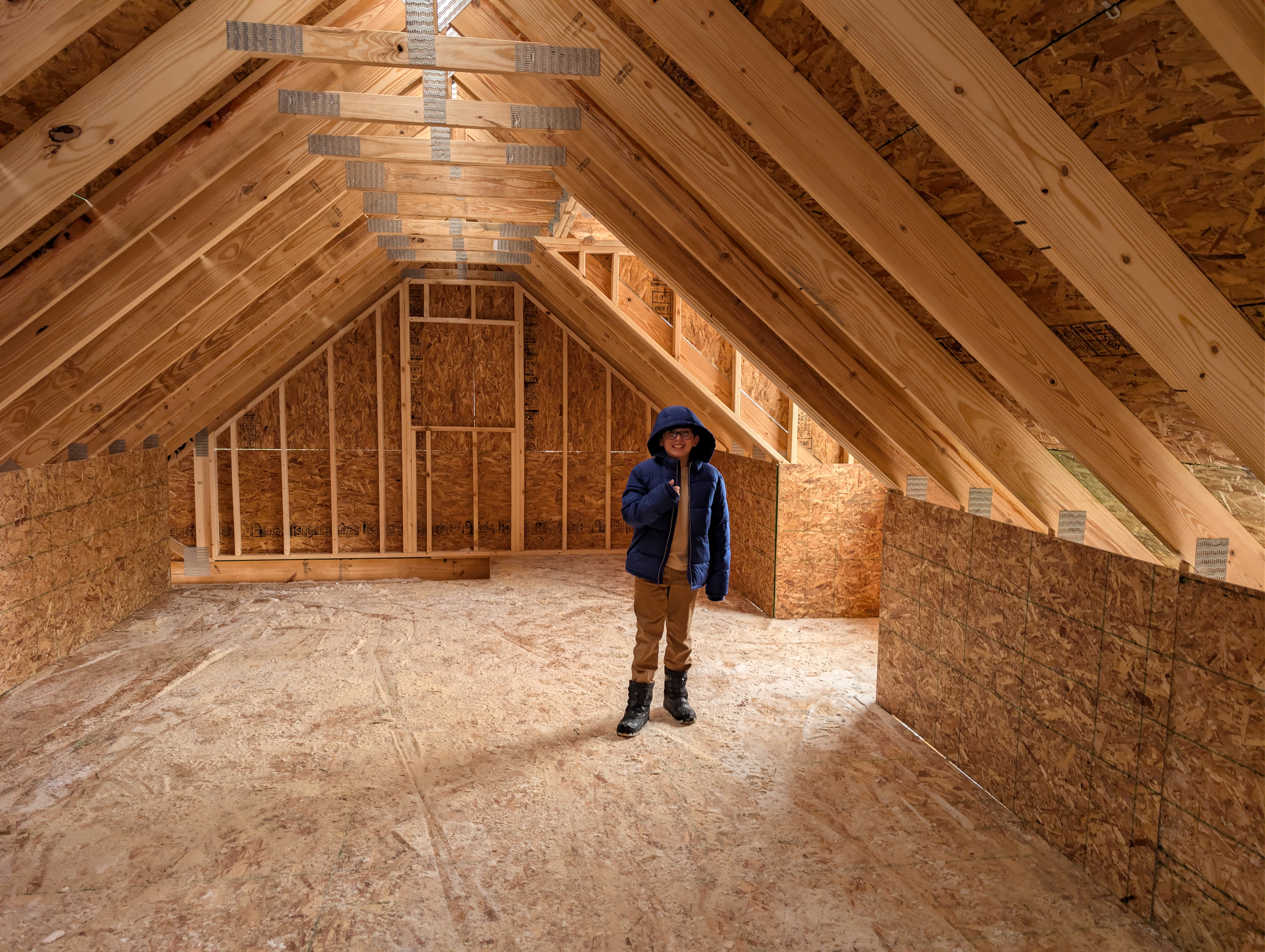 Standing in framed loft space under roof rafters