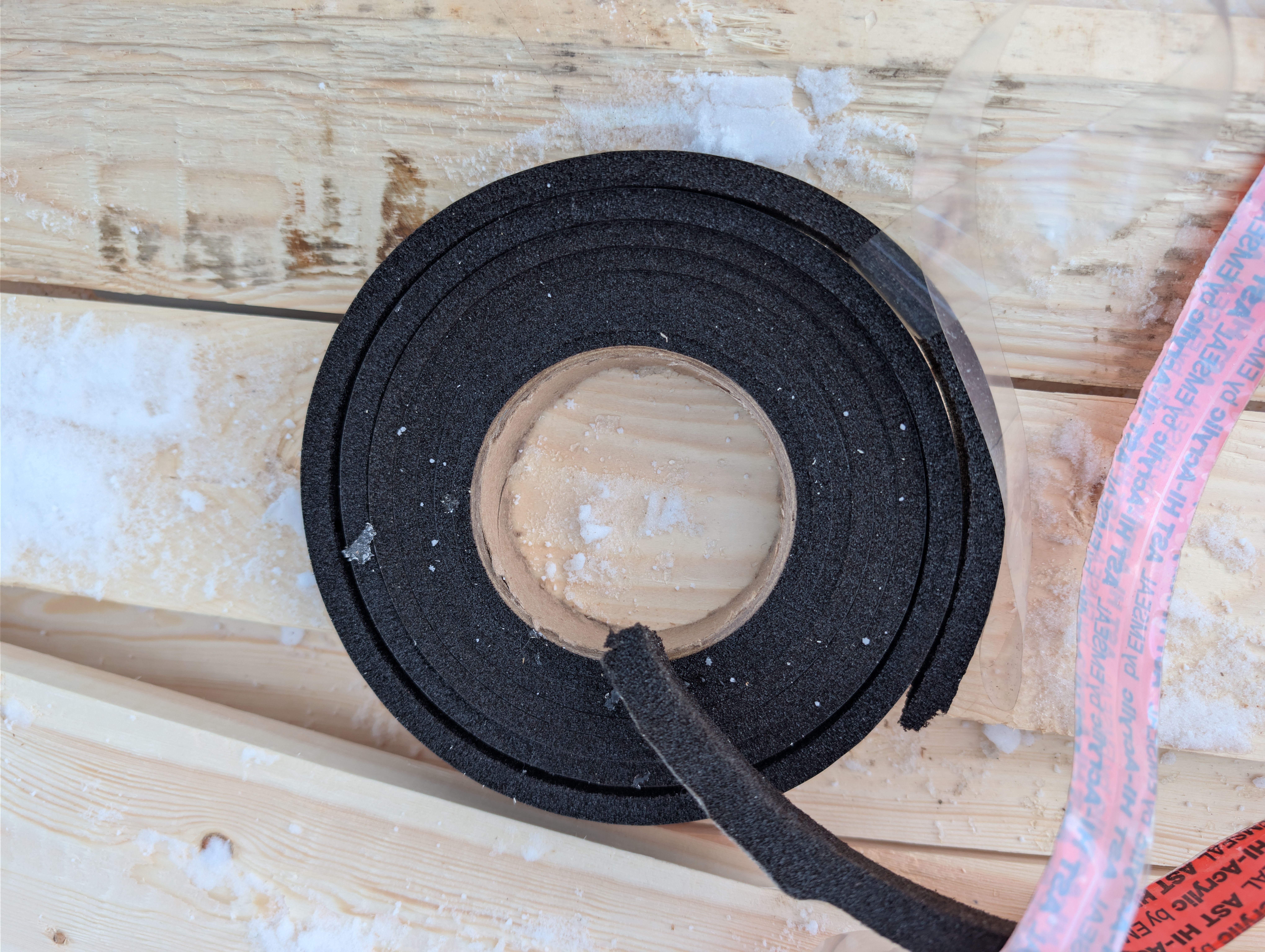 Roll of black foam closure strip on lumber