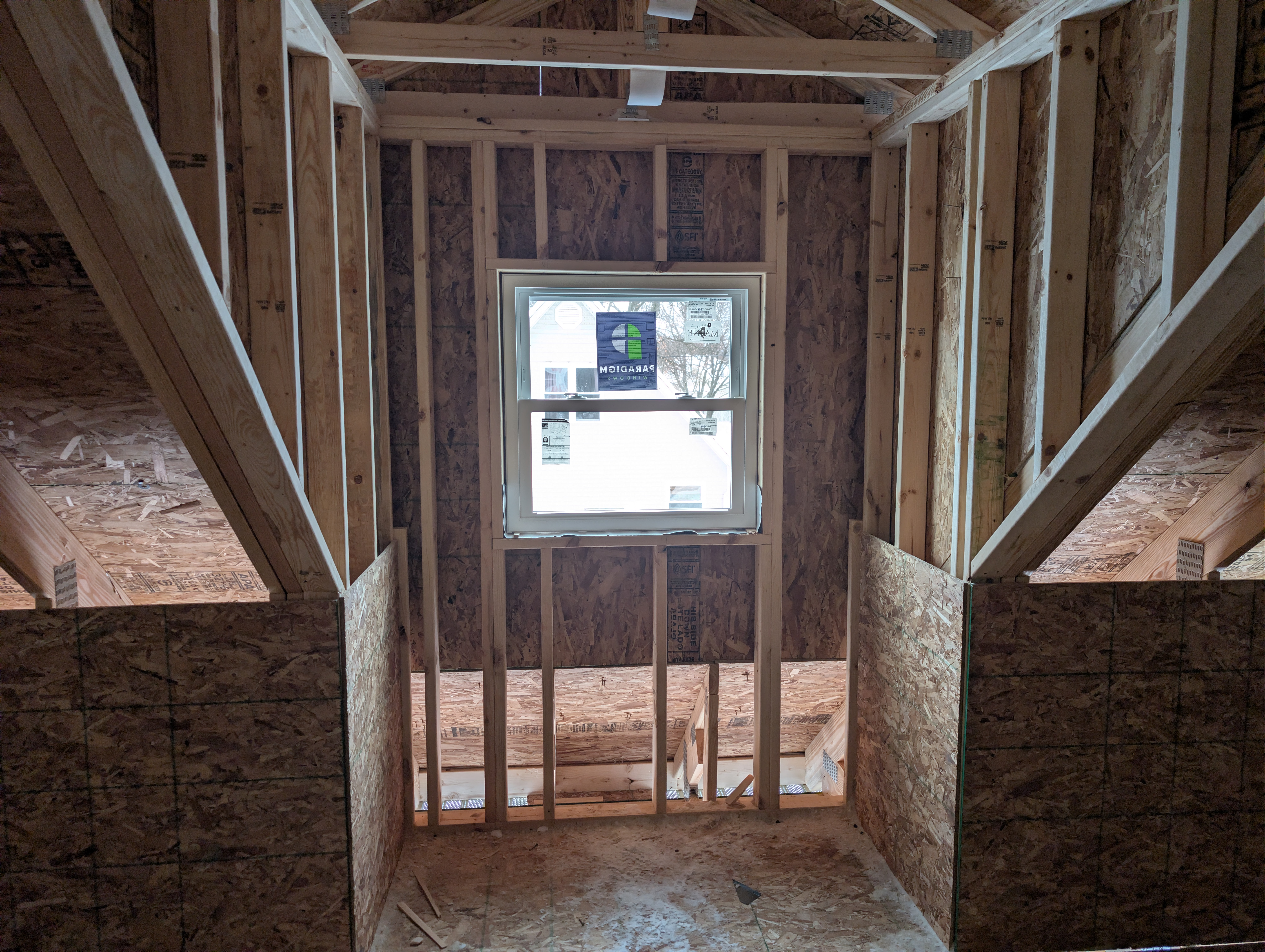 Dormer window installed above stair opening in loft framing