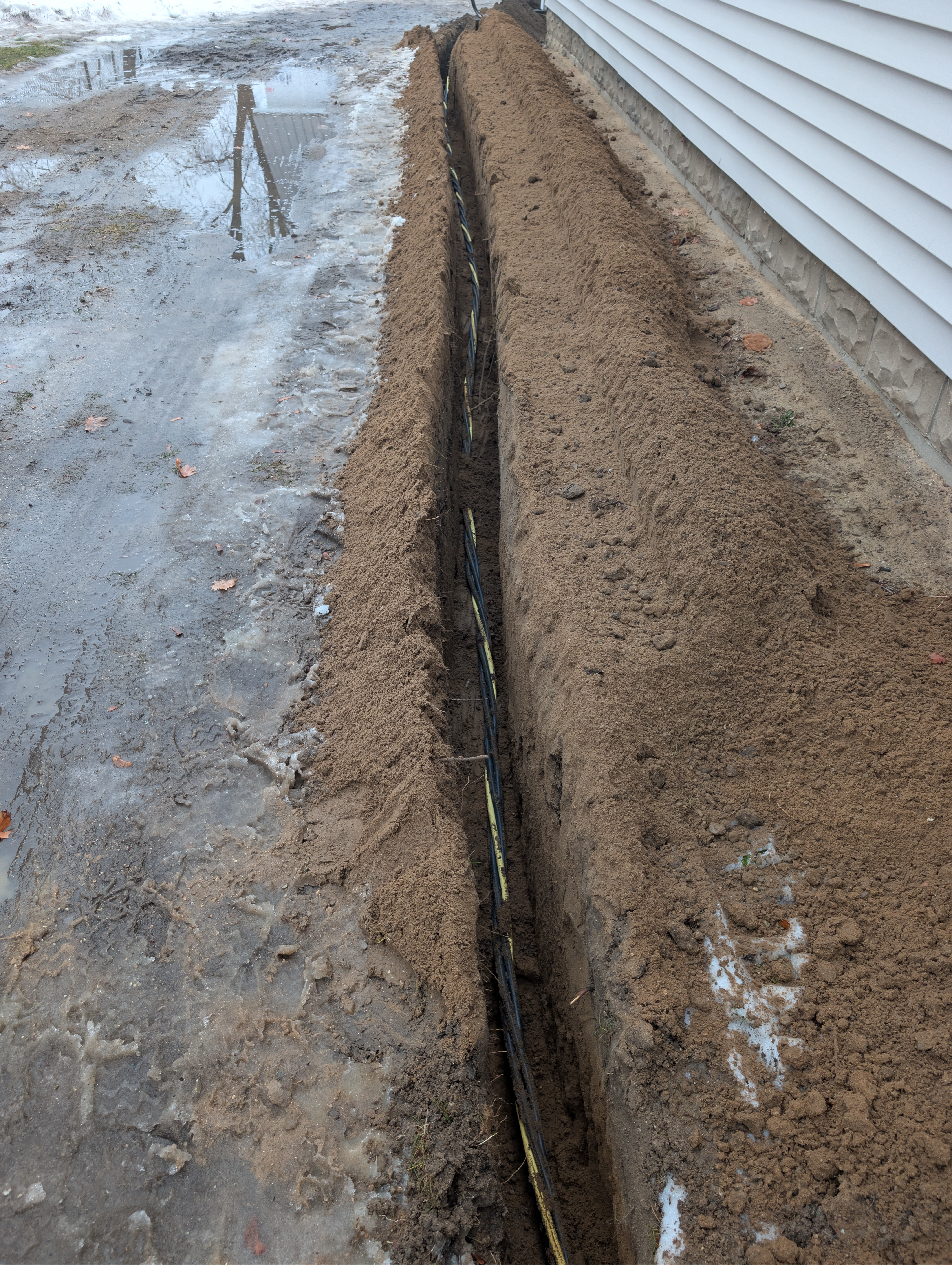 Full length view of electrical trench along house with wire installed