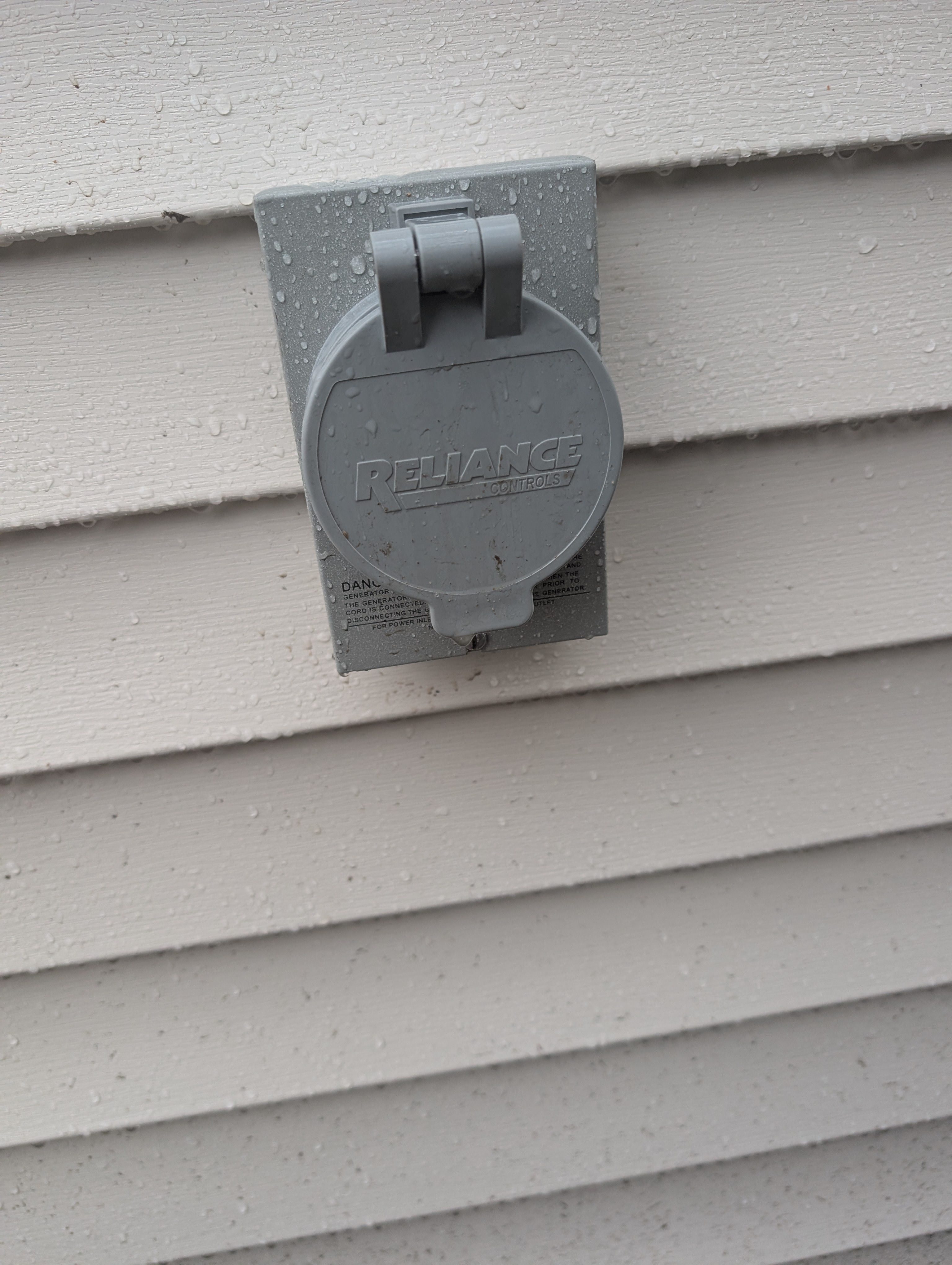 Reliance generator inlet box on garage siding with cover closed